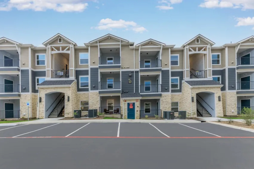 Three-story apartment building exterior with stone and siding