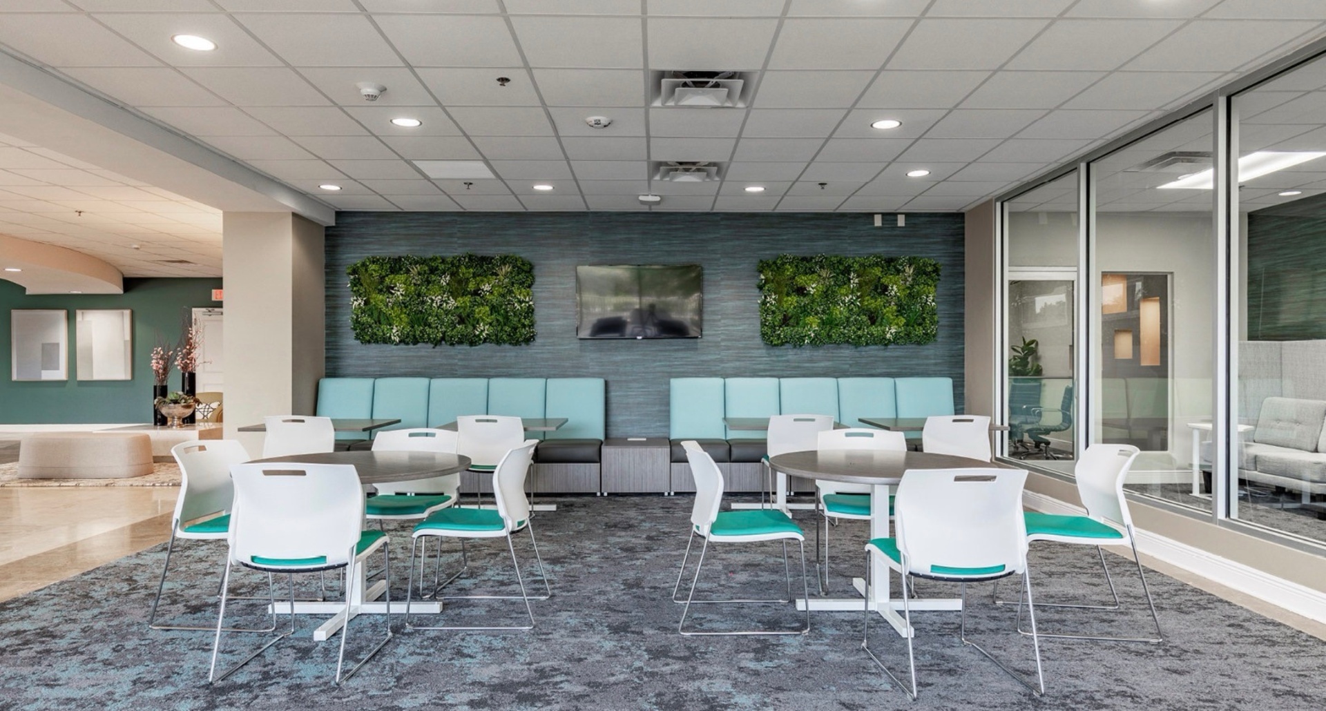 Community room with banquette seating and living walls