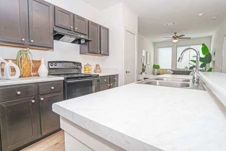 Kitchen with dark cabinetry and quartz counters